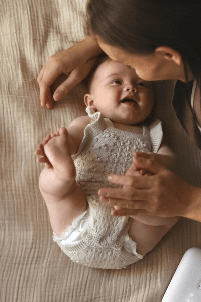 Seorang ibu memompa ASI di kasur dengan bayi
