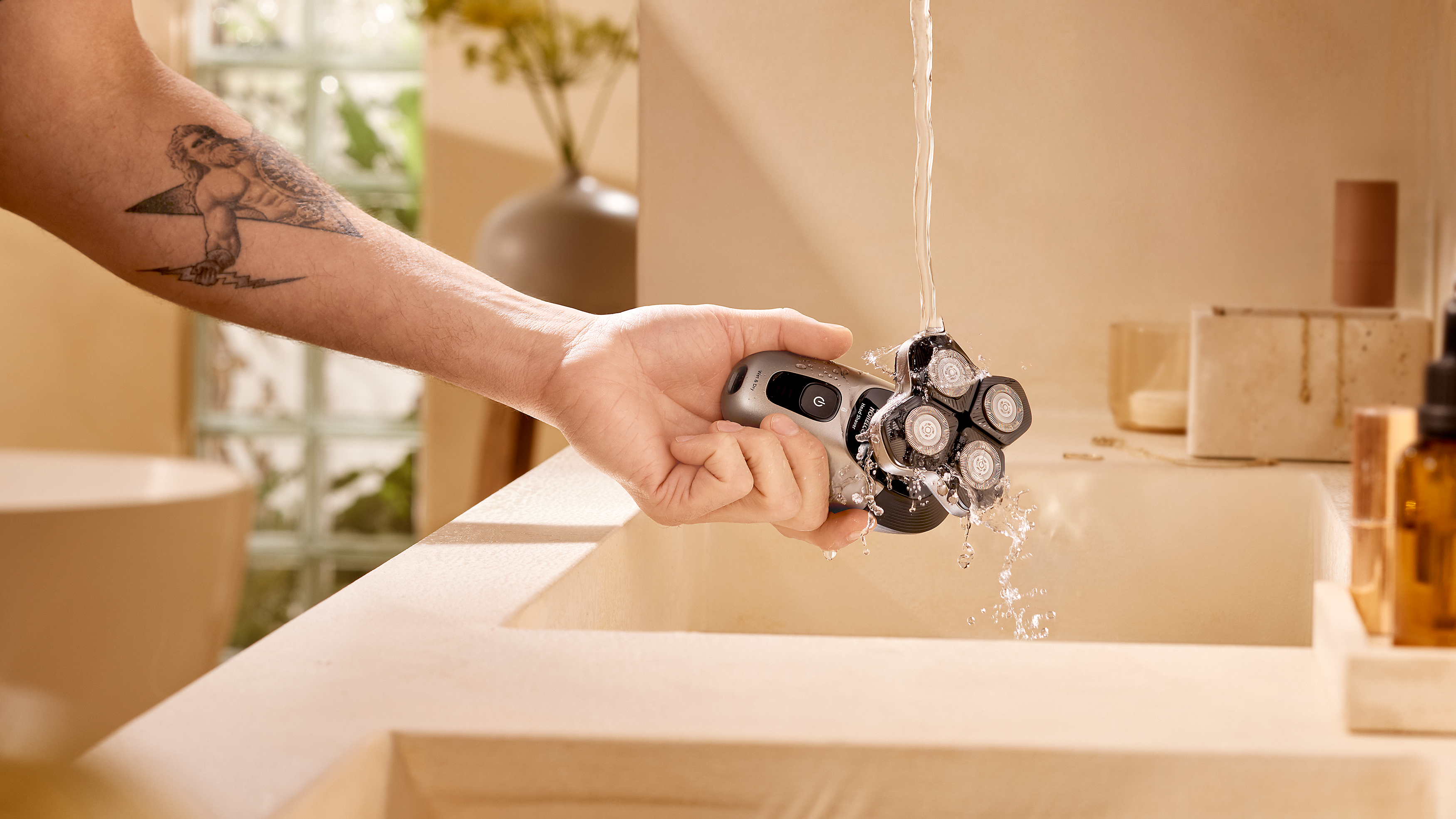 Philips waterproof head shaver being rinsed clean