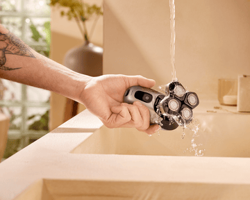 Philips waterproof head shaver being rinsed clean