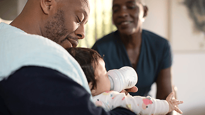 Hombre alimentando a un bebé con un biberón Philips Avent Natural Response