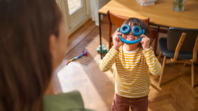 Dva sourozenci si hrají s dětskými sluchátky na uších
