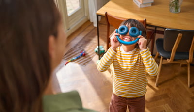 Twee broers en zussen spelen terwijl ze on-ear koptelefoons voor kinderen gebruiken