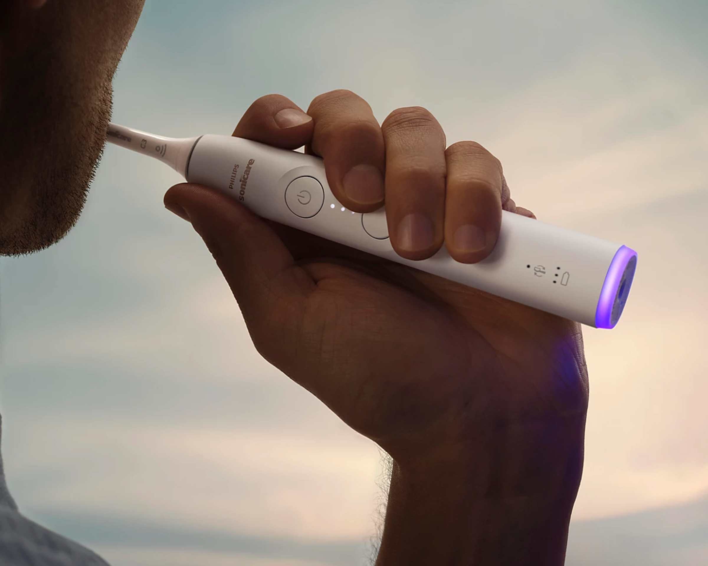 A patient holding a Sonicare 6300 with the base lighting up.