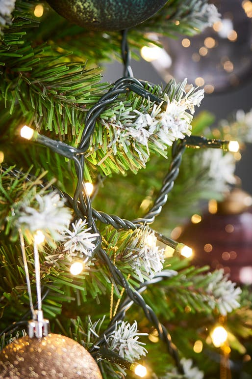 Sala de estar de natal branca e dourada com árvore de natal e