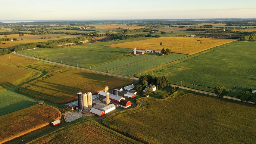 Aerial view of farm, red barns, corn field in September.