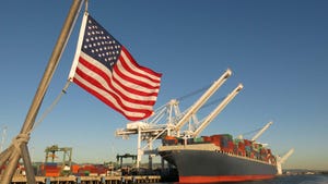 American flag with large export ship in the background