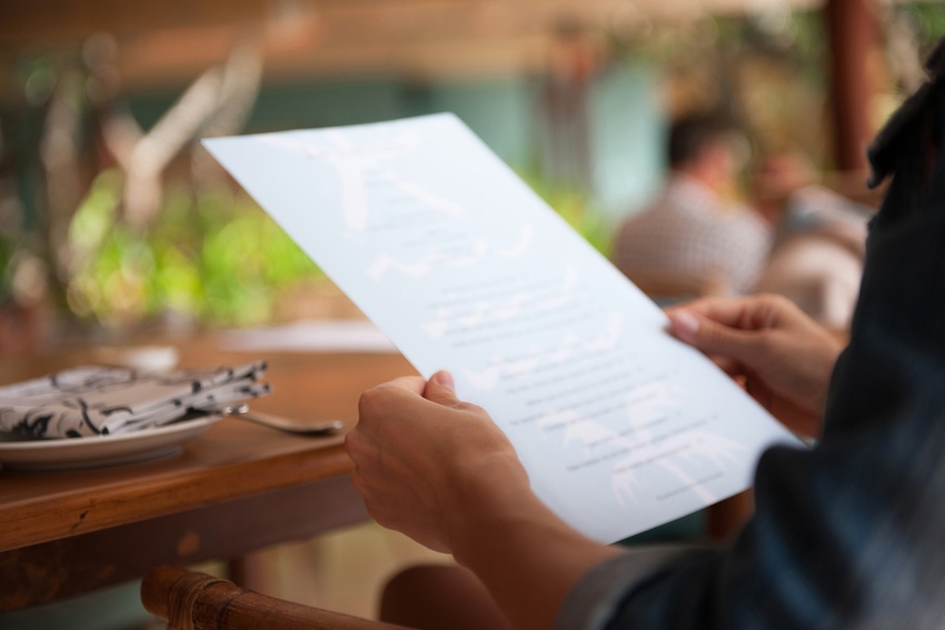 person holding restaurant menu out of focus