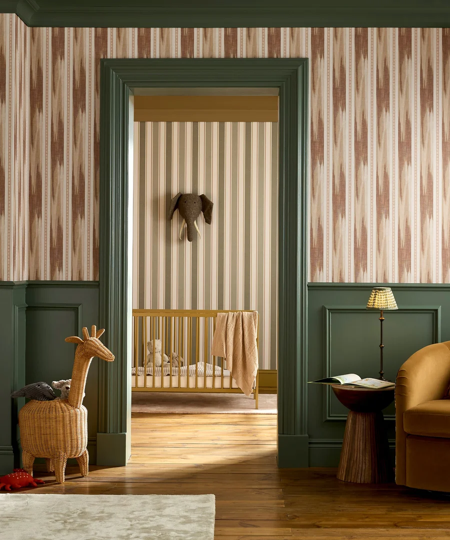 Childrens bedroom with cot and foundry stripe forest wallpaper and forge stripe terracotta wallpaper