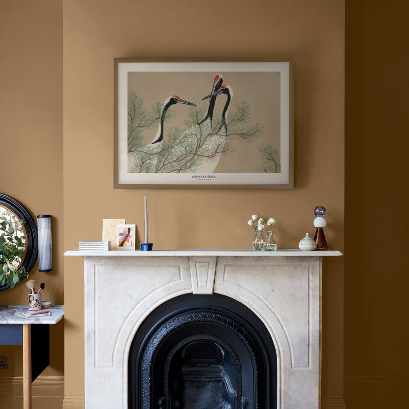Framed wall art hung on a chimney breast above a fire place