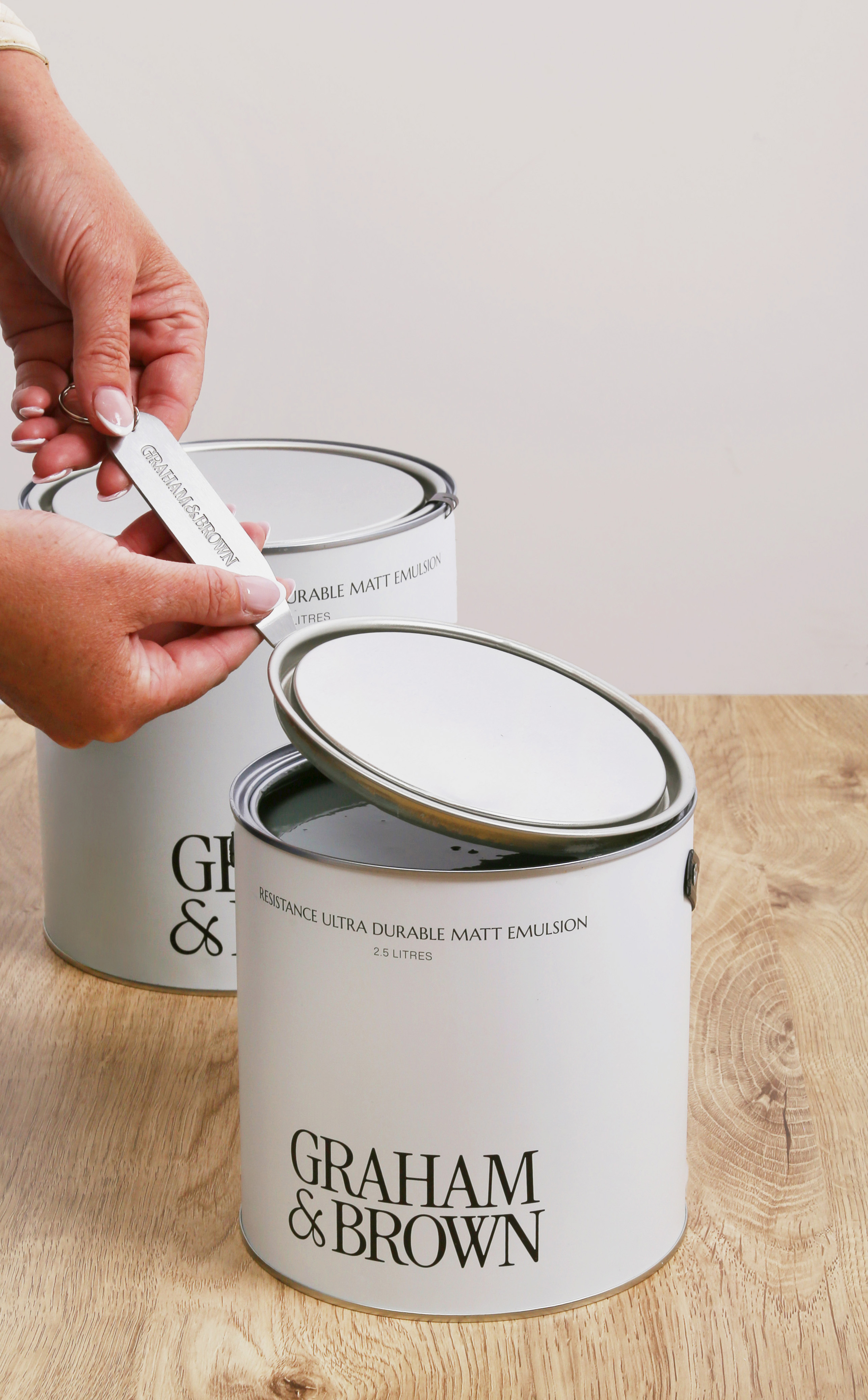 Image of someone opening graham & brown paint with the graham and brown tin opener