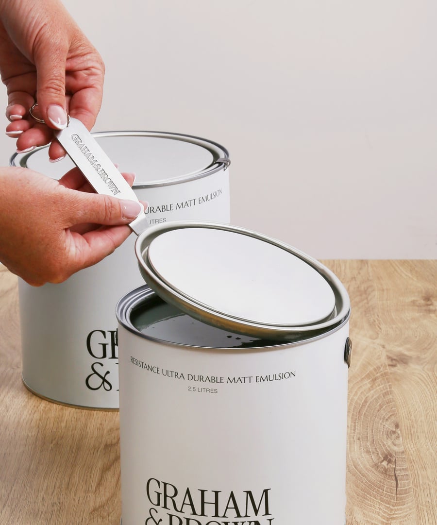 Image of someone opening graham & brown paint with the graham and brown tin opener