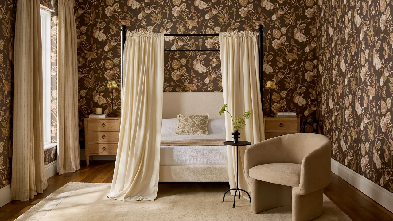 Orchard Tapestry Chocolade Behang in een slaapkamer met Zachte Kalksteen Gordijnen rond het hemelbed en Weide Steek Vlas Gordijnen die het raam sieren