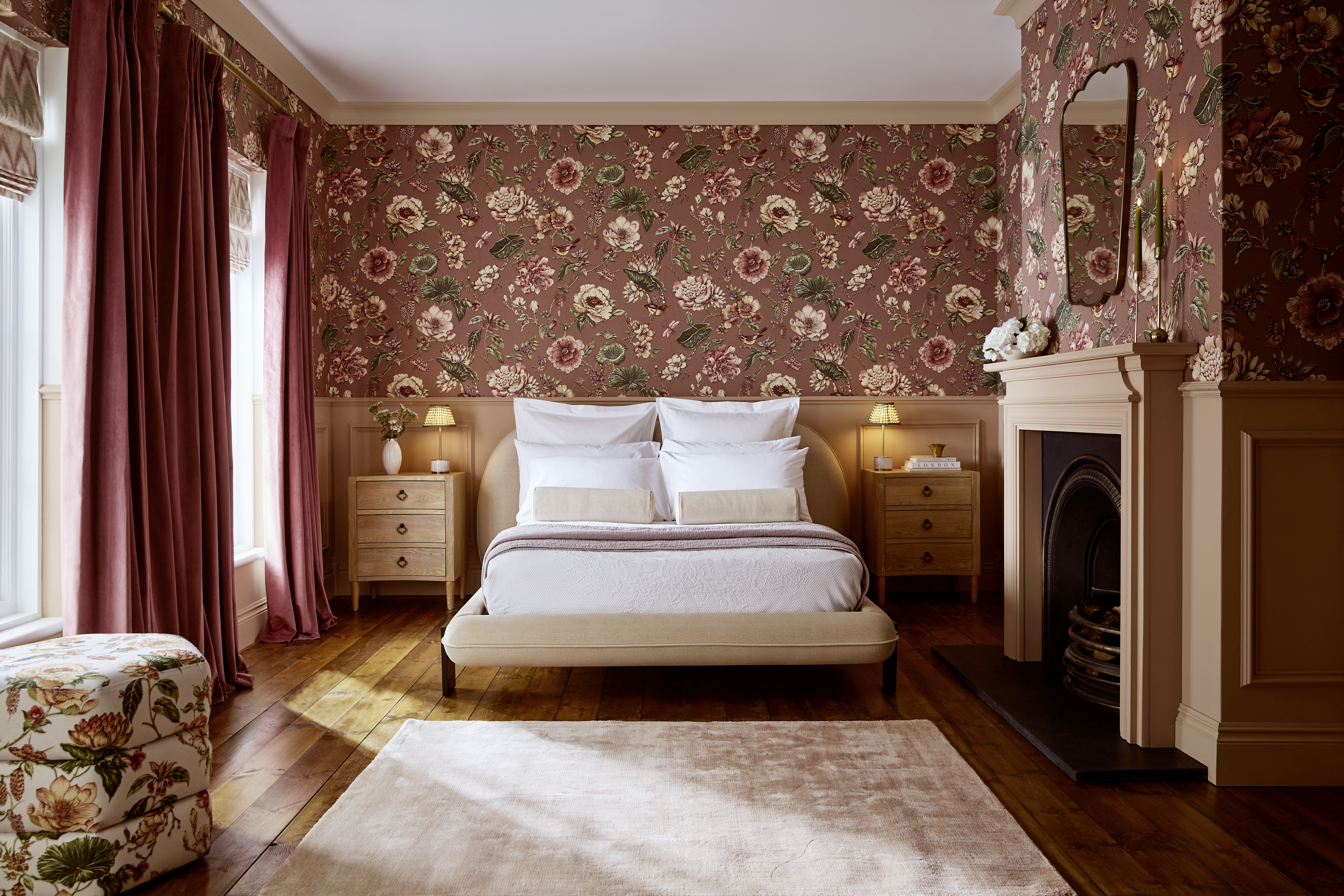 Roselle Grove Wallpaper in a Bedroom with Rose Earth Paint, Opulence Vintage Mulberry Curtains, Zigzagare Green Blinds, and a Roselle Grove pouffe. 