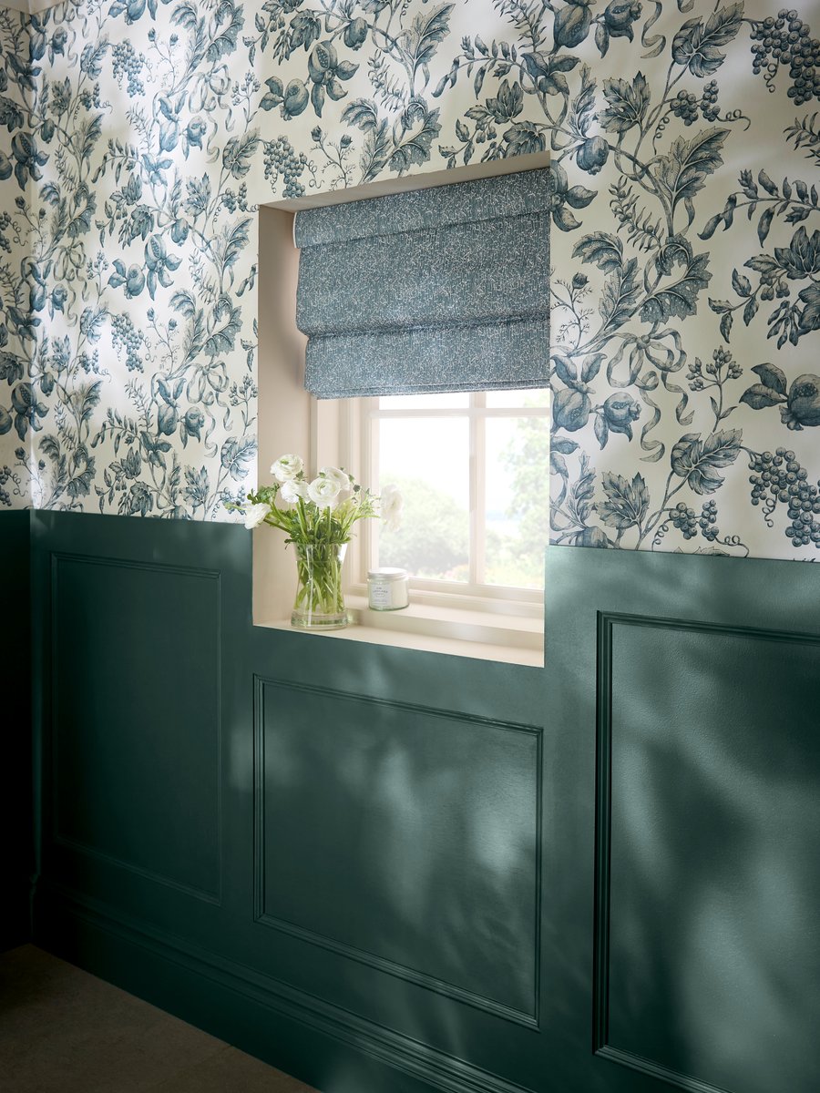 Celeste Denim roman blind paired with Roman Navy wallpaper in a hallway