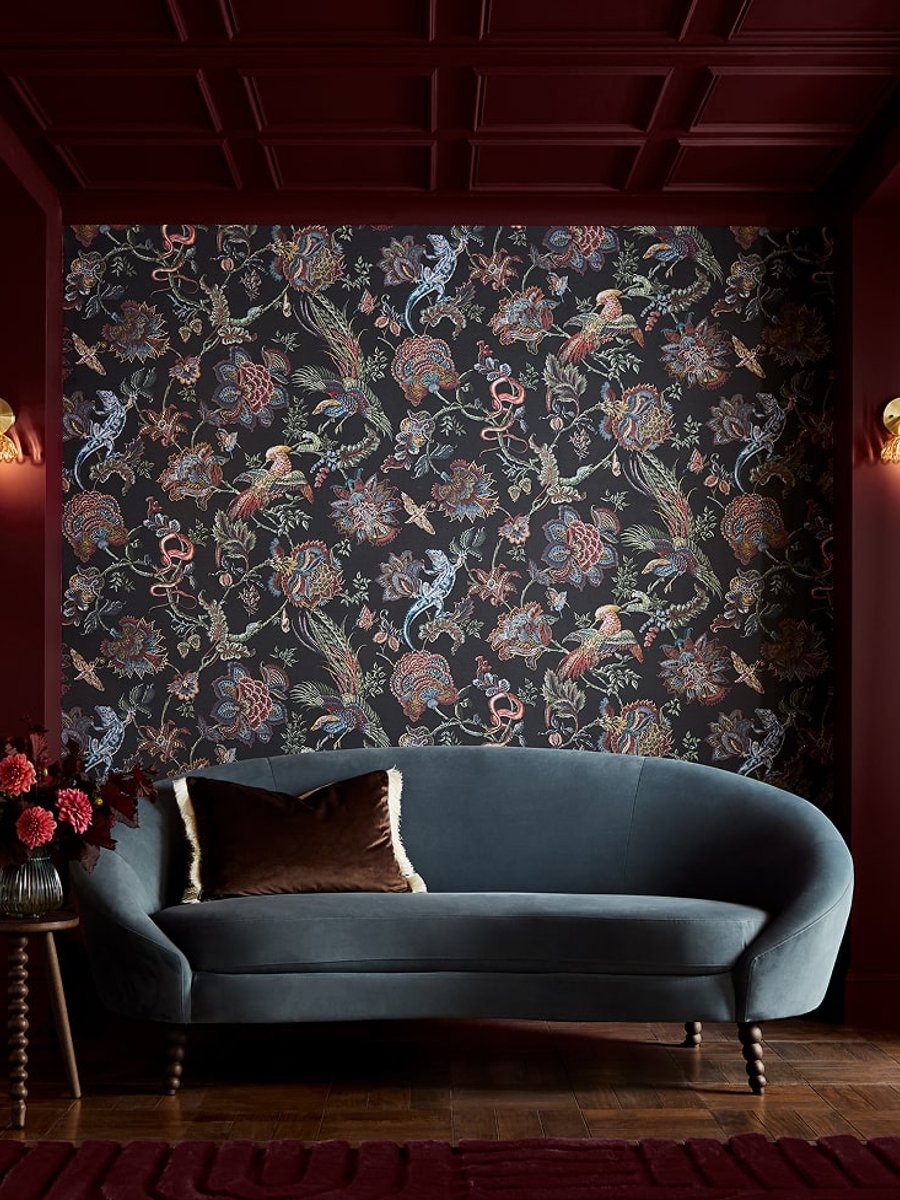 Eternal Weave wallpaper and Divine Damson paint in a living room setting with a blue sofa next to a side table with pink flowers