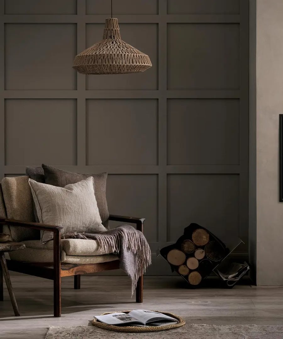 Panelled wall featuring warm baguette paint and a rocking chair with cushions