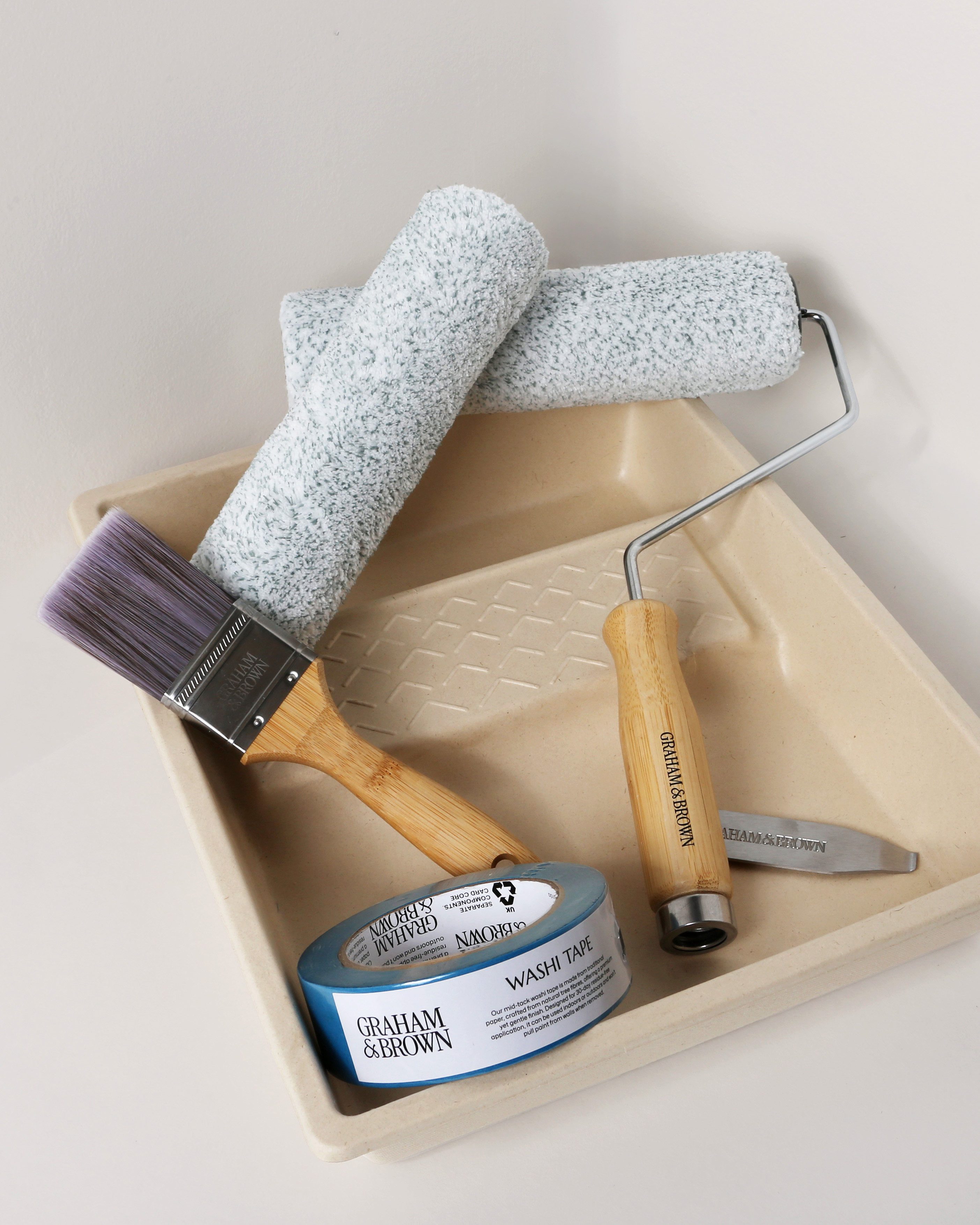 Image of paint kit including paint tray, paint brush, paint rollers and masking tape