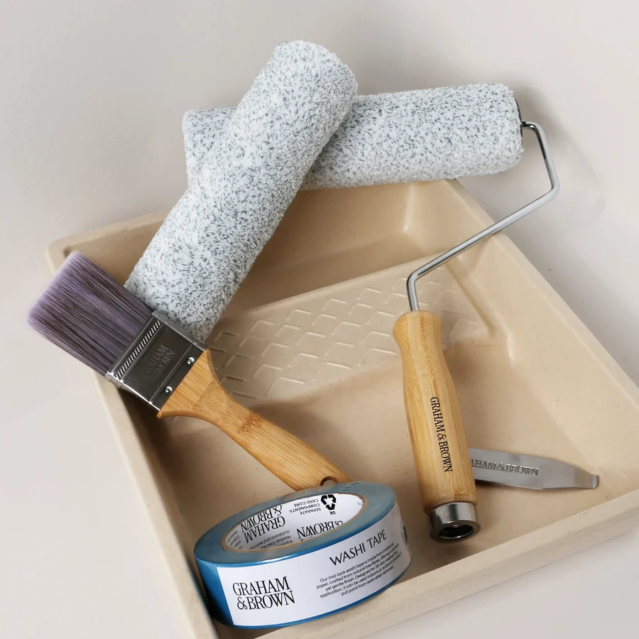 Image of paint kit including paint tray, paint brush, paint rollers and masking tape