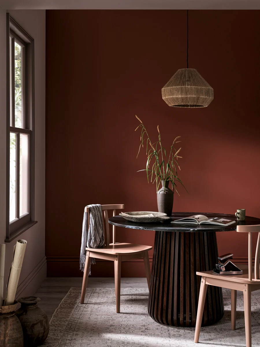 Dining Room table with plant and pimento paint on walls.