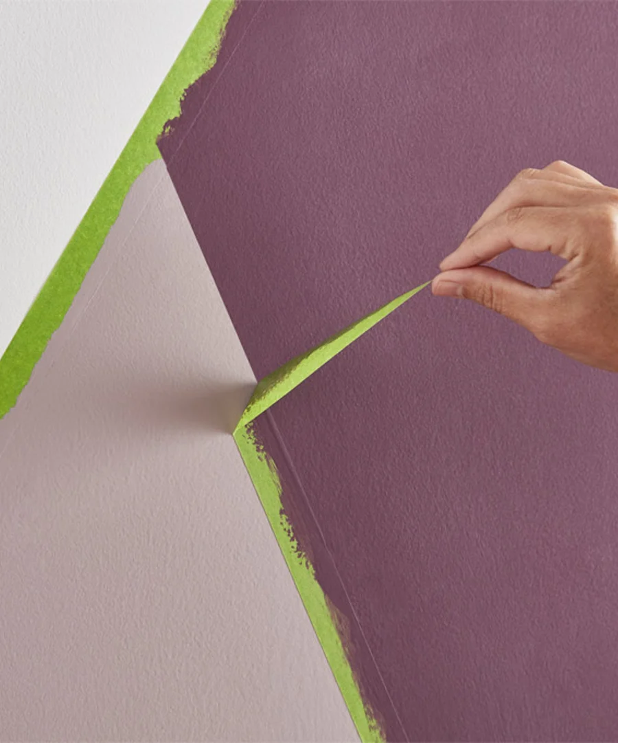 Image of somebody peeling back masking tape to reveal a geometric design