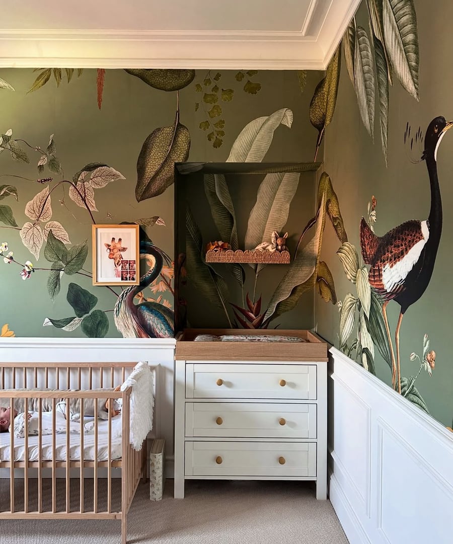 nursery room set featuring a cot and glasshouse sage mural
