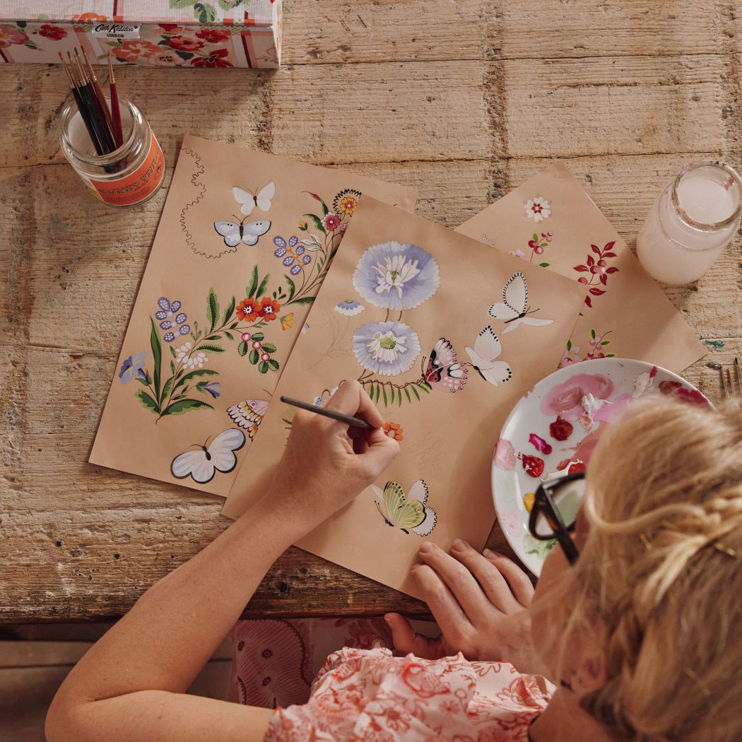 Cath Kidston wallpaper being sketched on a desk with paint.