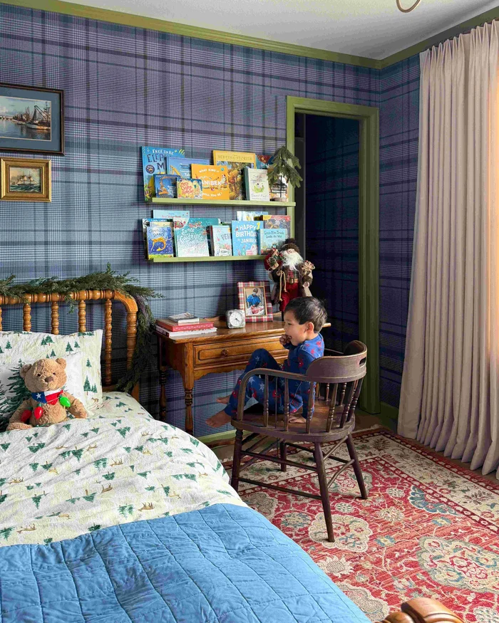 kids bedroom with bed, red rug and heritage blue plaid wallpaper