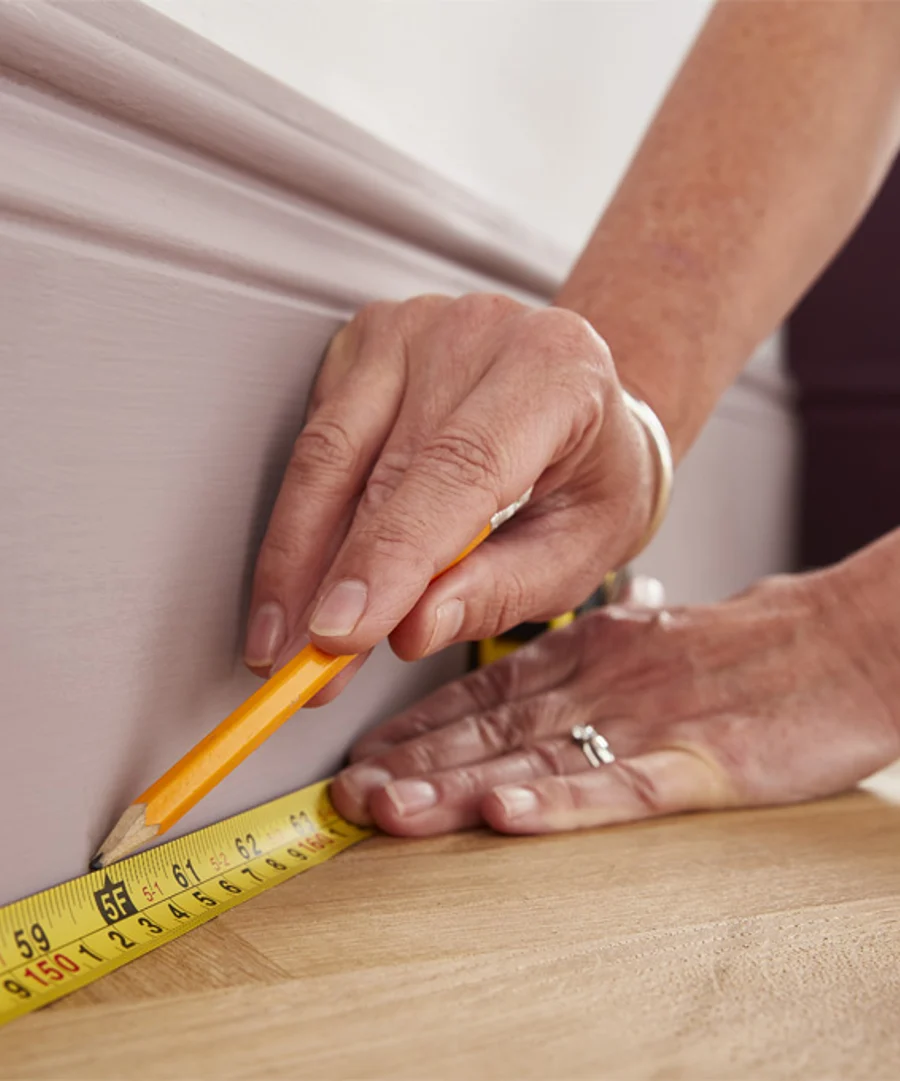 someone measuring a design to paint