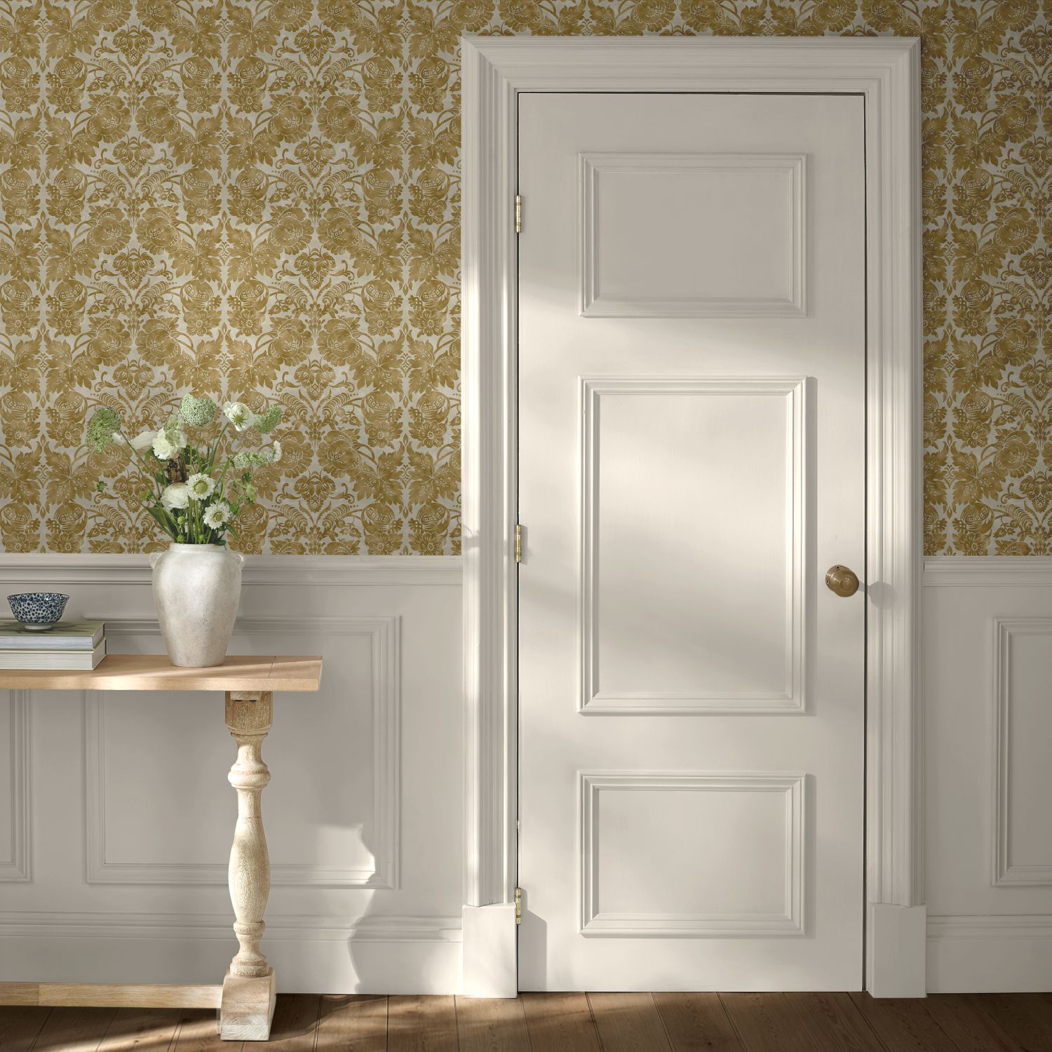 Martha Stewart Florentine Antique Gold Wallpaper in a hallway with console table and white door