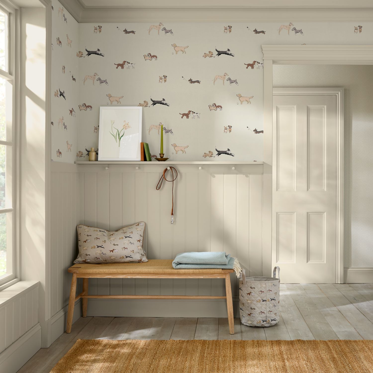 Sophie Allport Doggy Daycare Off White Wallpaper in a hallway with a bench with a cushion and blanket and a shelf.