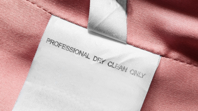 A zoomed in photo of a clothing label with a _dry clean only_ symbol