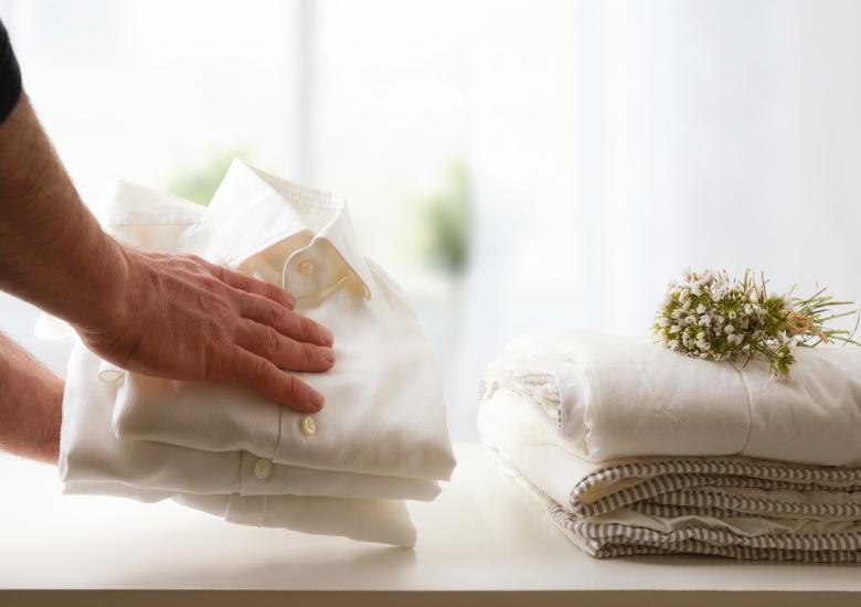 A stock of folded white dress shirts