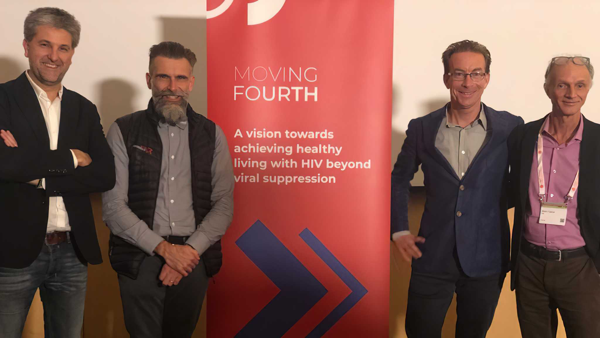 4 members of the Steering Committee standing with a Moving Fourth red banner in between them