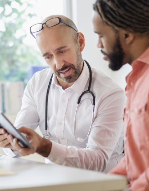 Healthcare professional and patient sitting together looking at a tablet screen