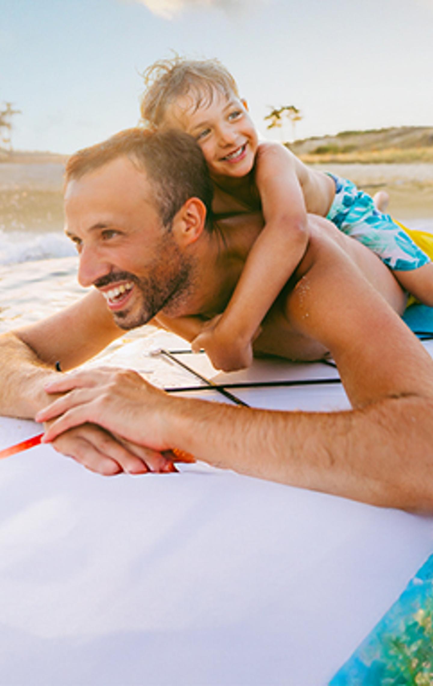 Mehr erfahren Vater und Sohn auf einem Surfboard
