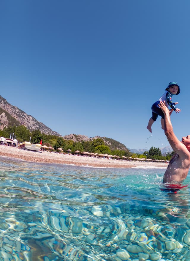 Familienurlaub Türkei Mann spielt mit Kind im Meer