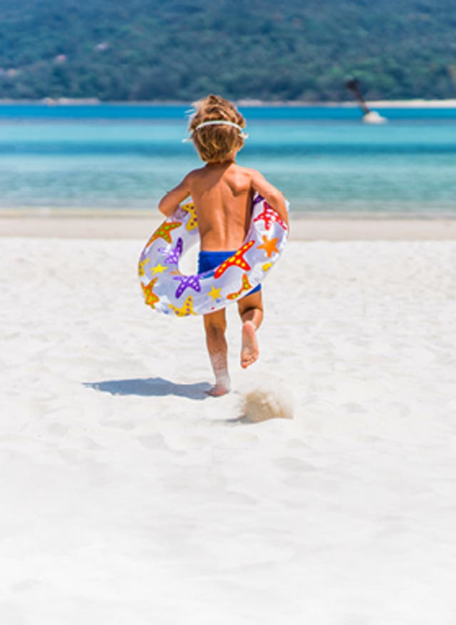 Mehr Infos hier Junge mit Schwimmring am Strand