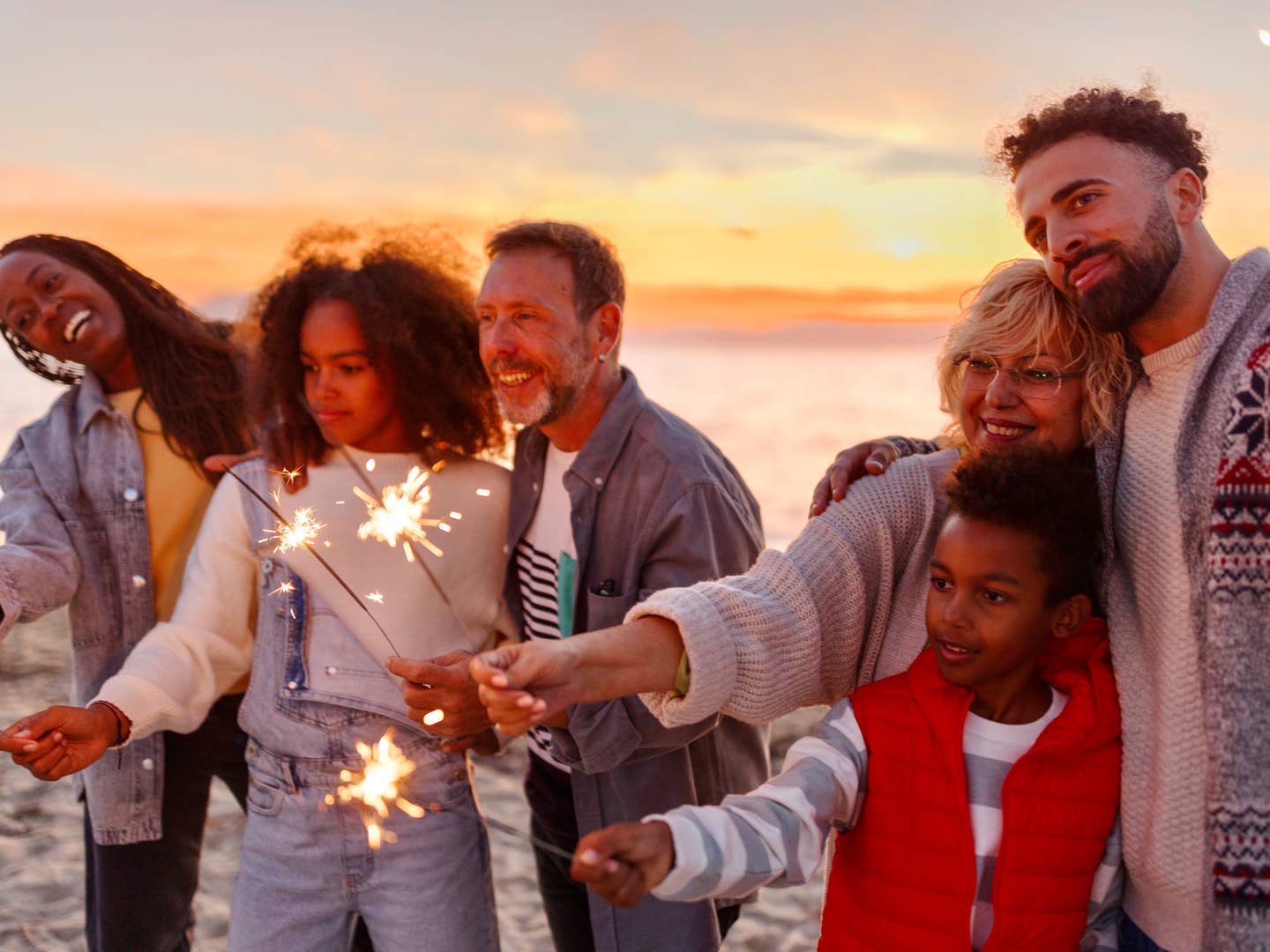 Freunde mit Wunderkerzen am Strand Freunde mit Wunderkerzen am Strand