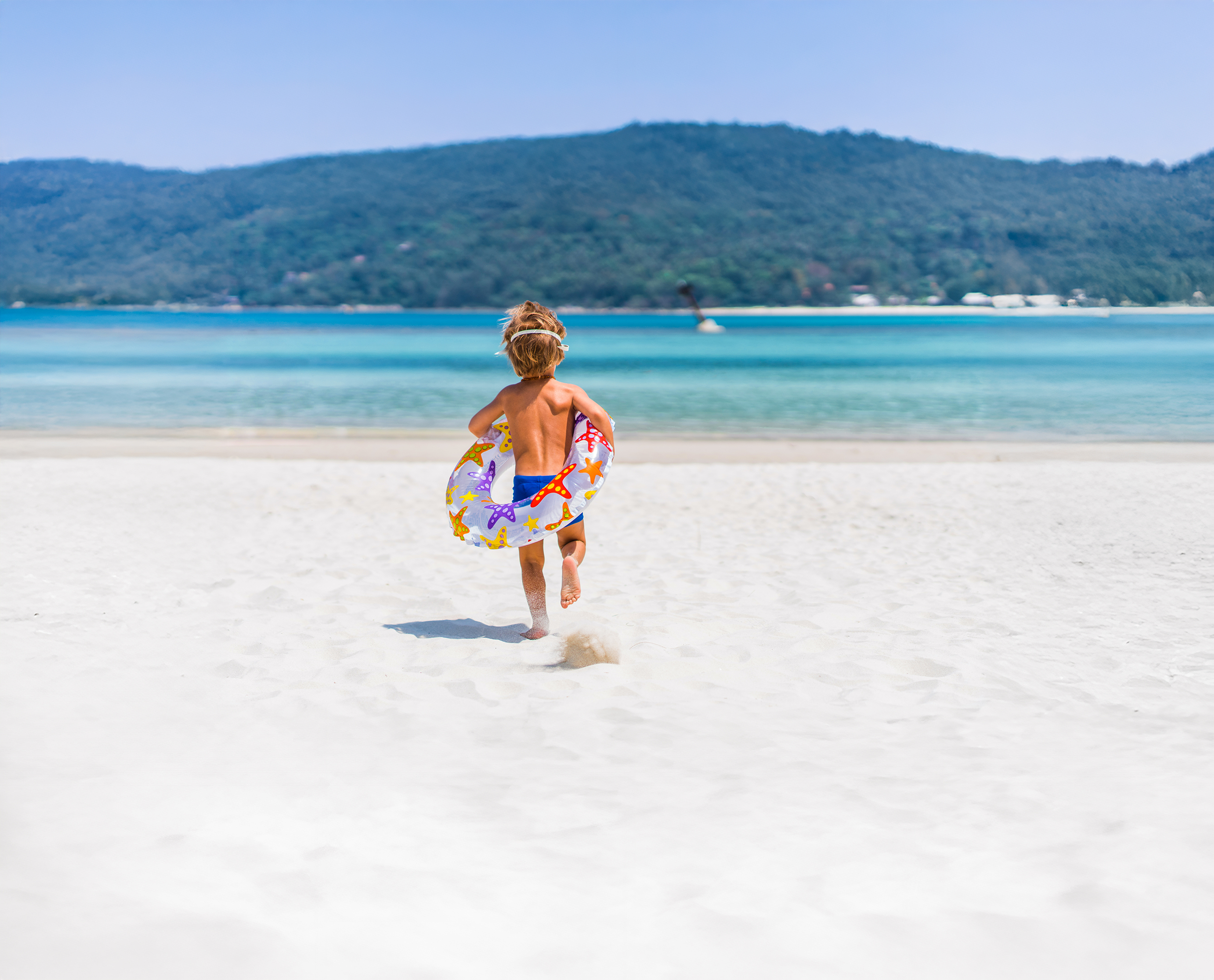 Kind mit Schwimmring am Strand
