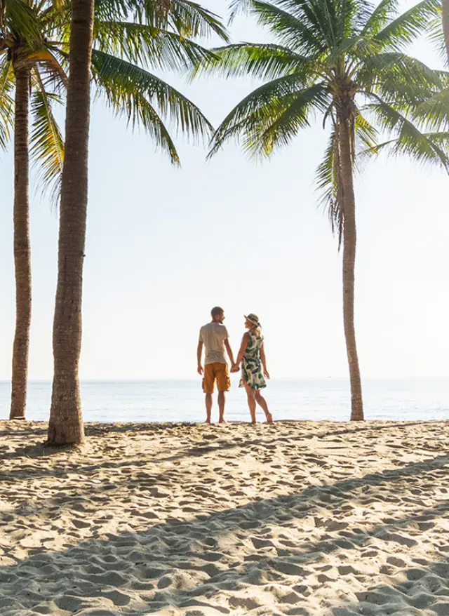 Adults-only-Urlaub Paar am Strand unter Palmen