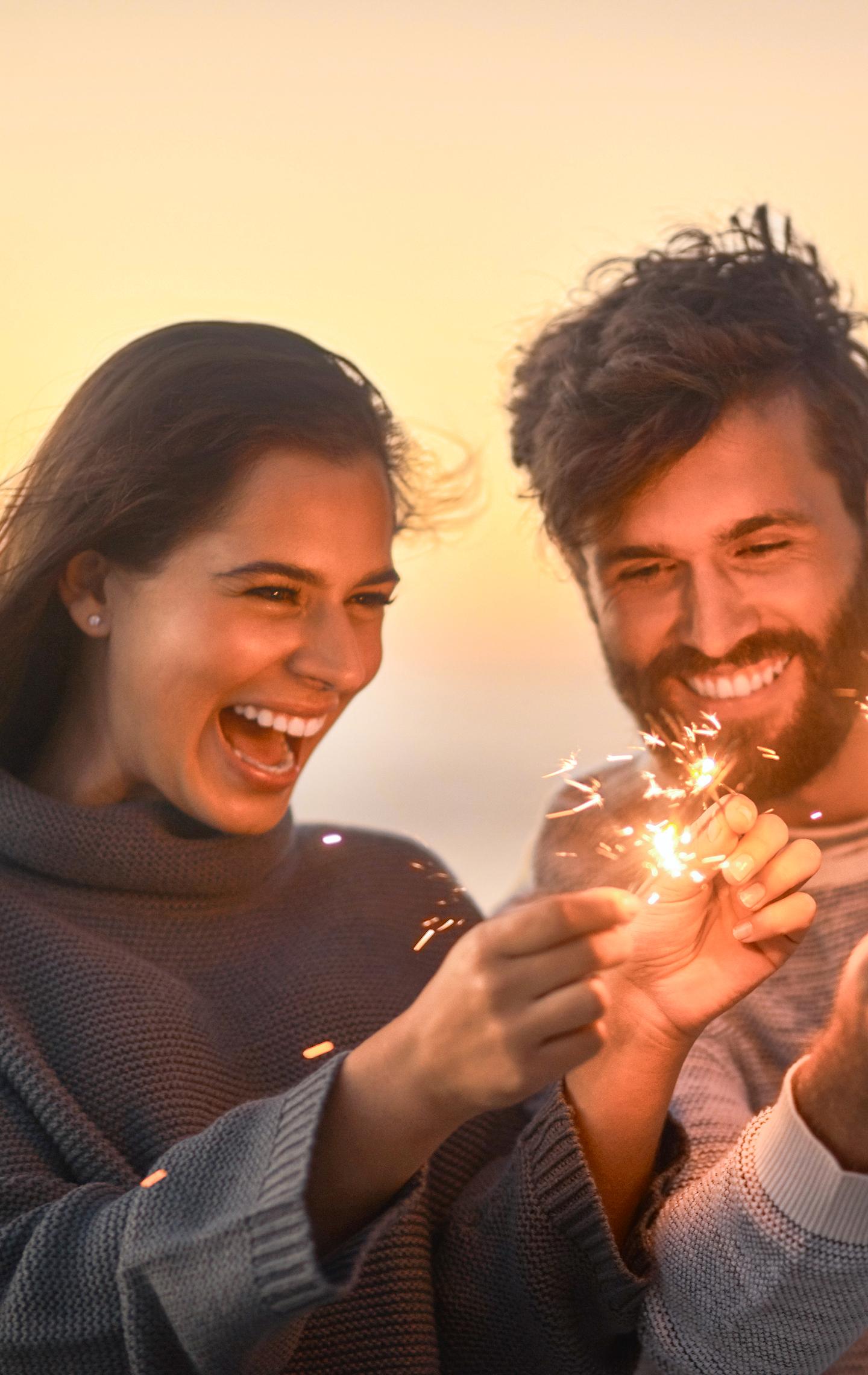 Jetzt entdecken Paar am Strand mit Wunderkerzen