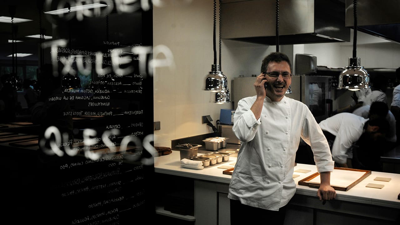Chef talks on phone in restaurant kitchen Chef talks on phone in restaurant kitchen
