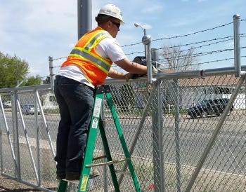 Billy Fogg of Rocky Mountain Access Controls installs rollers on a slide gate at Morgan County Mini Storage in Colorado. (Photo courtesy of Brandon Wimmler and Sentinel Systems Corp.)