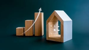 Three increasingly taller wood blocks with an arrow pointing up on them next to a wood house indicating increased asset value Three increasingly taller wood blocks with an arrow pointing up on them next to a wood house indicating increased asset value