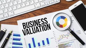 The words business valuation on a desk with charts and graphics The words business valuation on a desk with charts and graphics