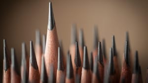 An image of sharp pencils tips on a brown background An image of sharp pencils tips on a brown background