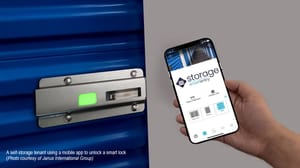 Someone using a cell phone to unlock a smart lock on a self-storage unit door Someone using a cell phone to unlock a smart lock on a self-storage unit door