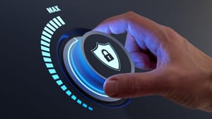 A hand turning a dial with a security symbol on it, cranking it up to max A hand turning a dial with a security symbol on it, cranking it up to max