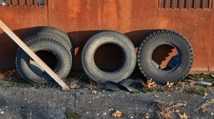 Four tires leaning against the side of a building Four tires leaning against the side of a building