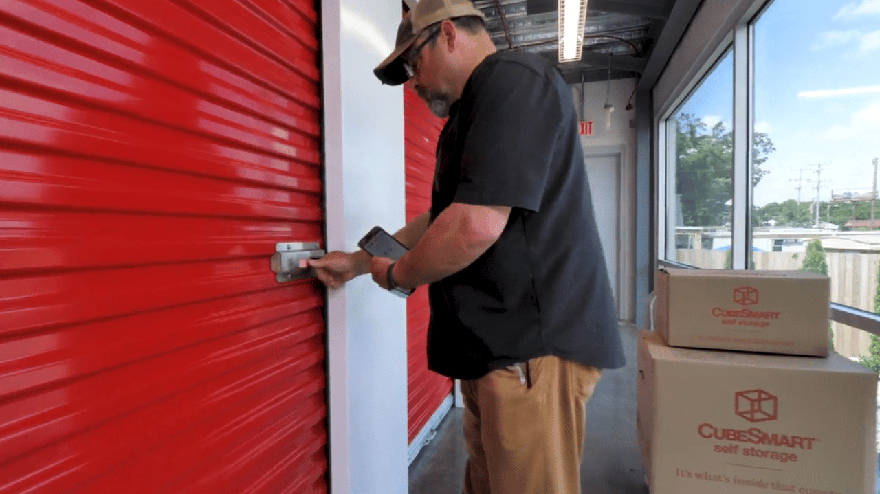 An image of a male customer opening the red door to his climate-controlled self-storage unit using a mobile app An image of a male customer opening the red door to his climate-controlled self-storage unit using a mobile app